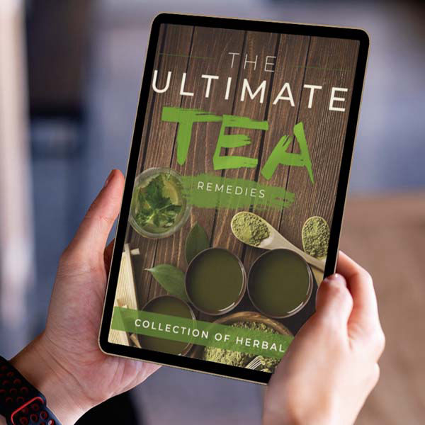 Person holding a tablet displaying an eBook titled ‘The Ultimate Tea Remedies: Collection of Herbal Teas,’ featuring images of green tea cups, leaves, and matcha powder on a wooden background.